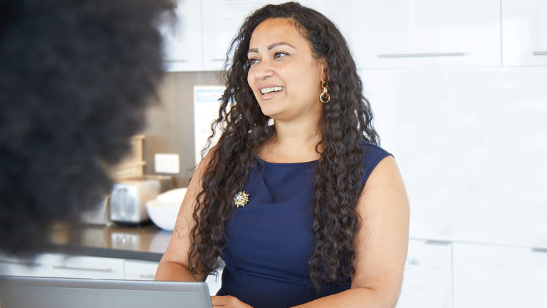 Female Lazard Colleague Smiling and Talking in Kitchen