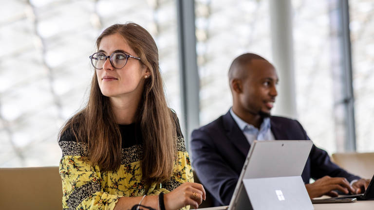 A woman thinking with a man in the background