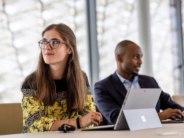A woman thinking with a man in the background